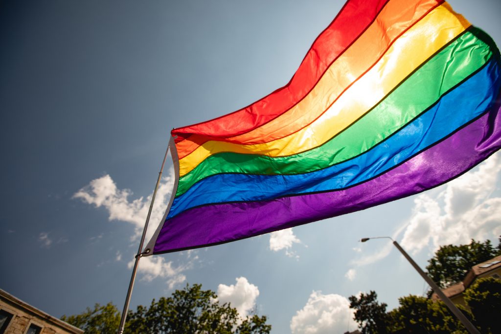 LGBTQIA+ flag. Concept photography of gay pride month at the street. Rainbow flags showing support for the LGBTQIA community with people at the LGBT event.